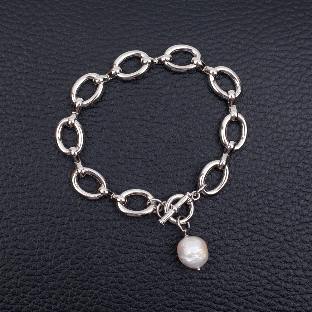 Bijoux du quotidien en argent et en acier inoxydable disposés sur une table.