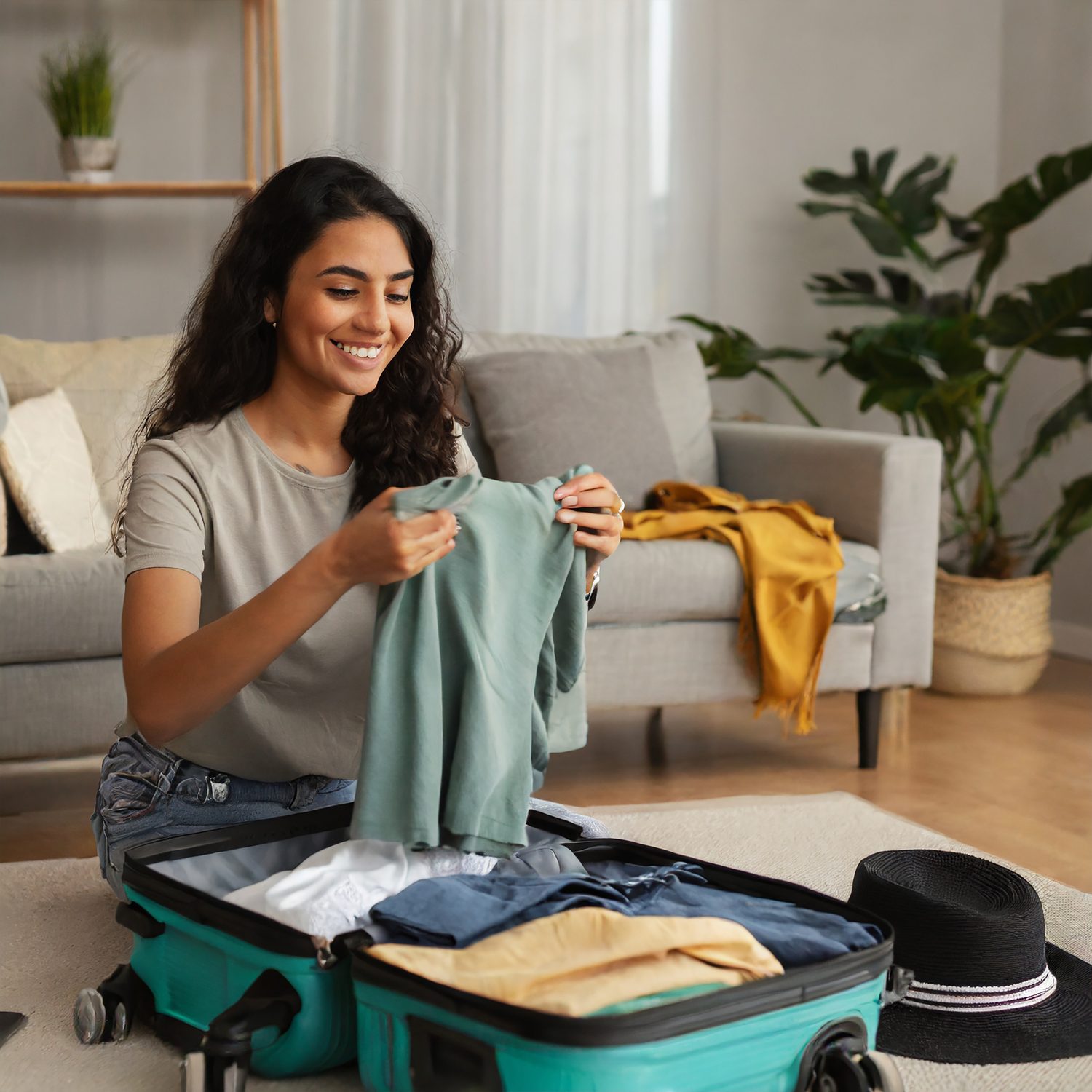 Voyageur préparant une valise cabine ouverte avec des vêtements avant un départ.