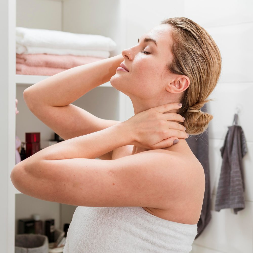 Personne appliquant une crème hydratante sur un visage marqué par des zones sèches.