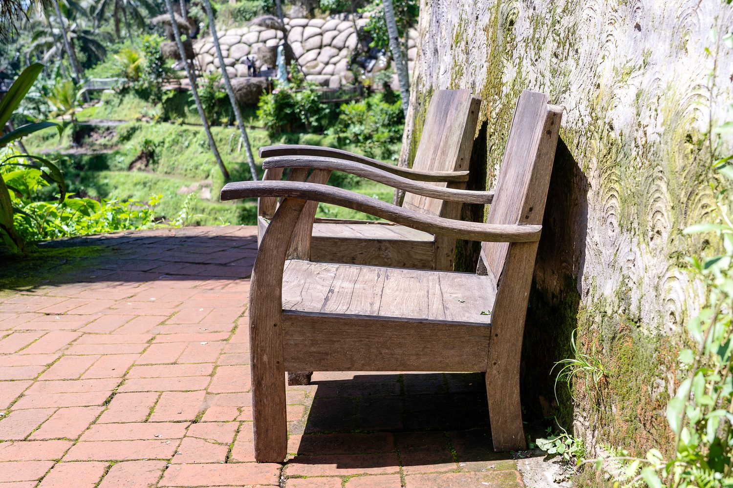 Petit jardin en longueur aménagé avec une terrasse, des plantes et un coin repas pour casser l’effet couloir.