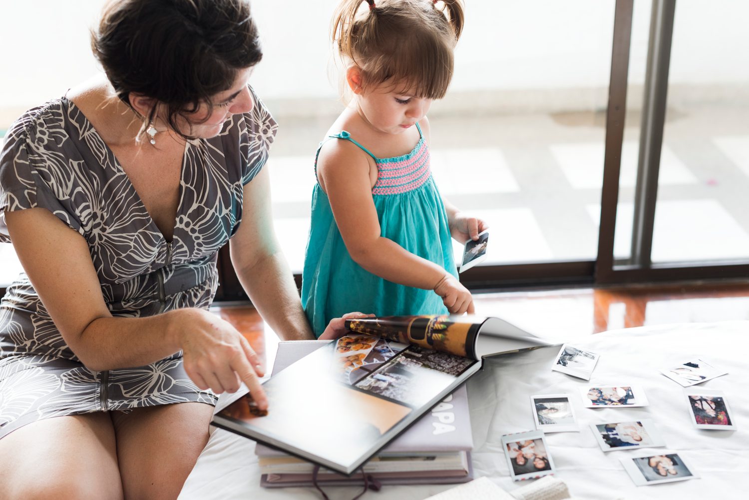 Une famille trie des photographies imprimées autour d’une table avant de créer un album.