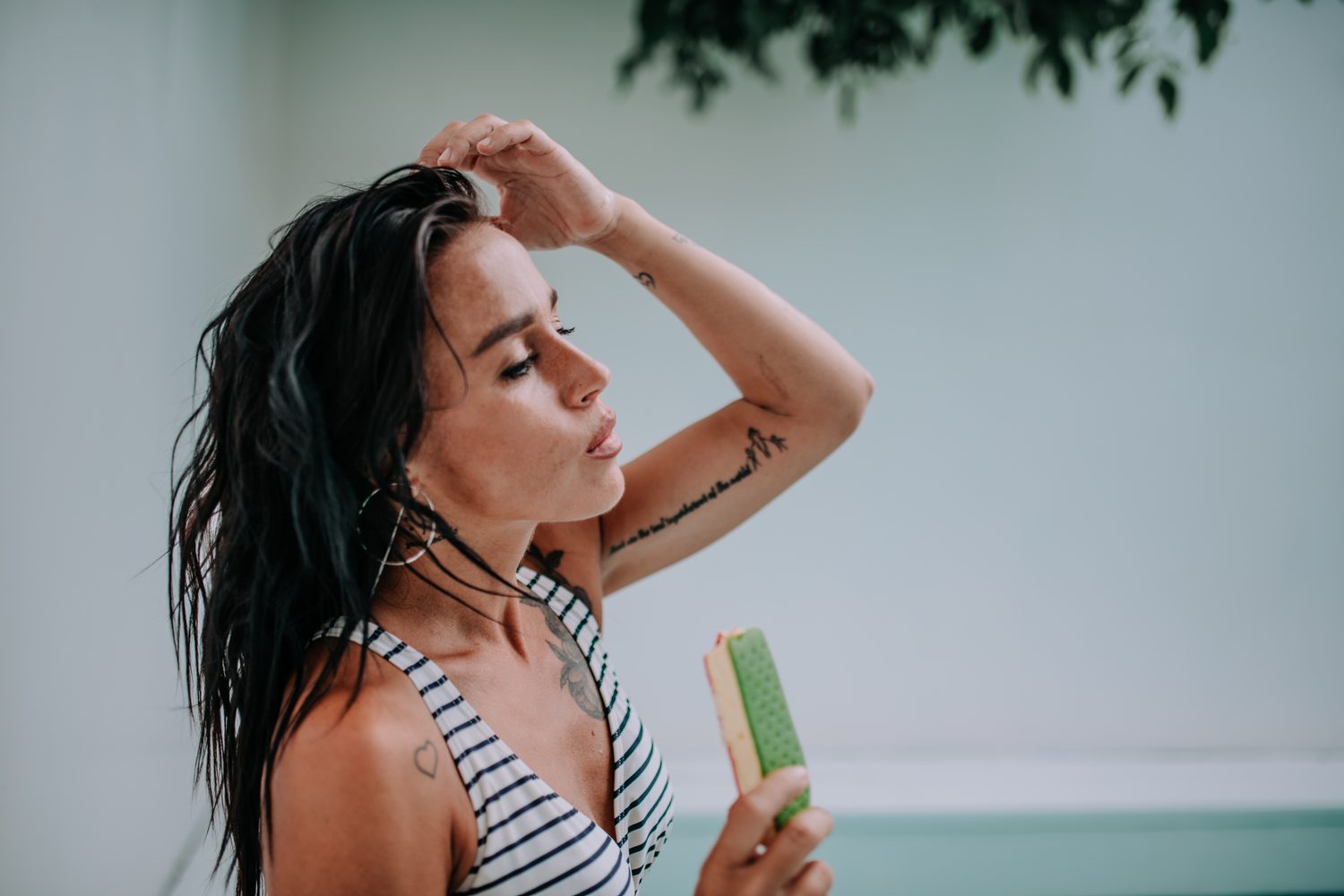 Femme appliquant du shampoing sur ses racines grasses dans la douche, avec des pointes sèches visibles.