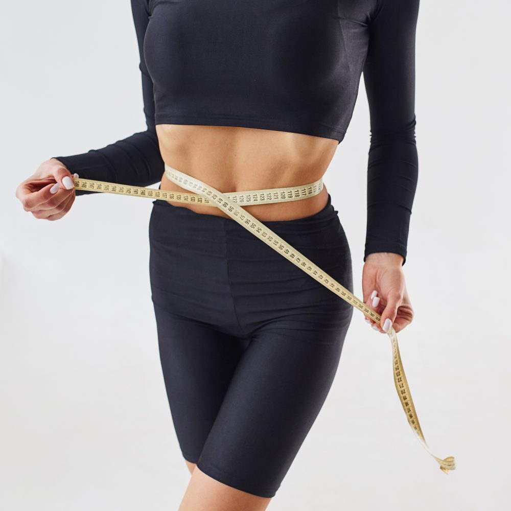 Mètre ruban placé autour de la taille pour déterminer la bonne taille de ceinture.